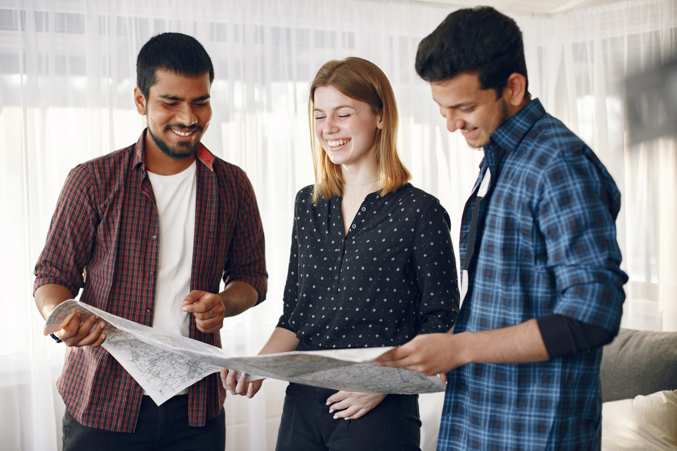 group of diverse friends looking at map in the bright room
